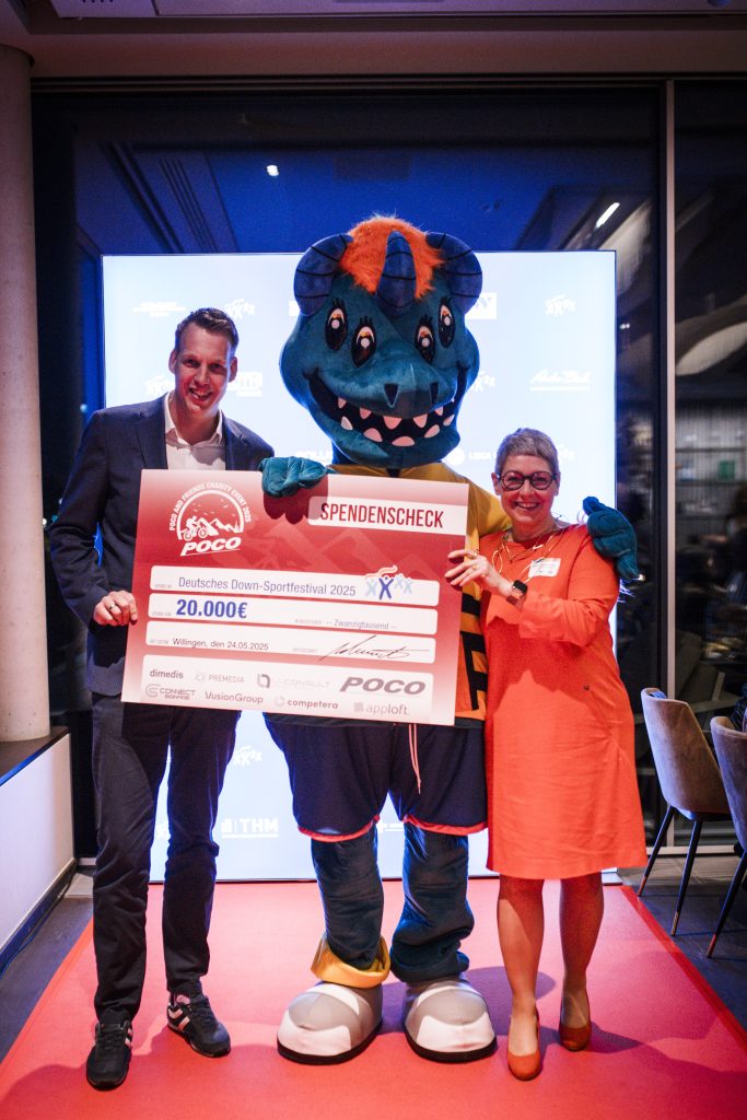 Sebastian Schrader, Bettina Eckert-Ziegler und das Maskottchen des Down-Sportlerfestivals auf dem roten Teppich.