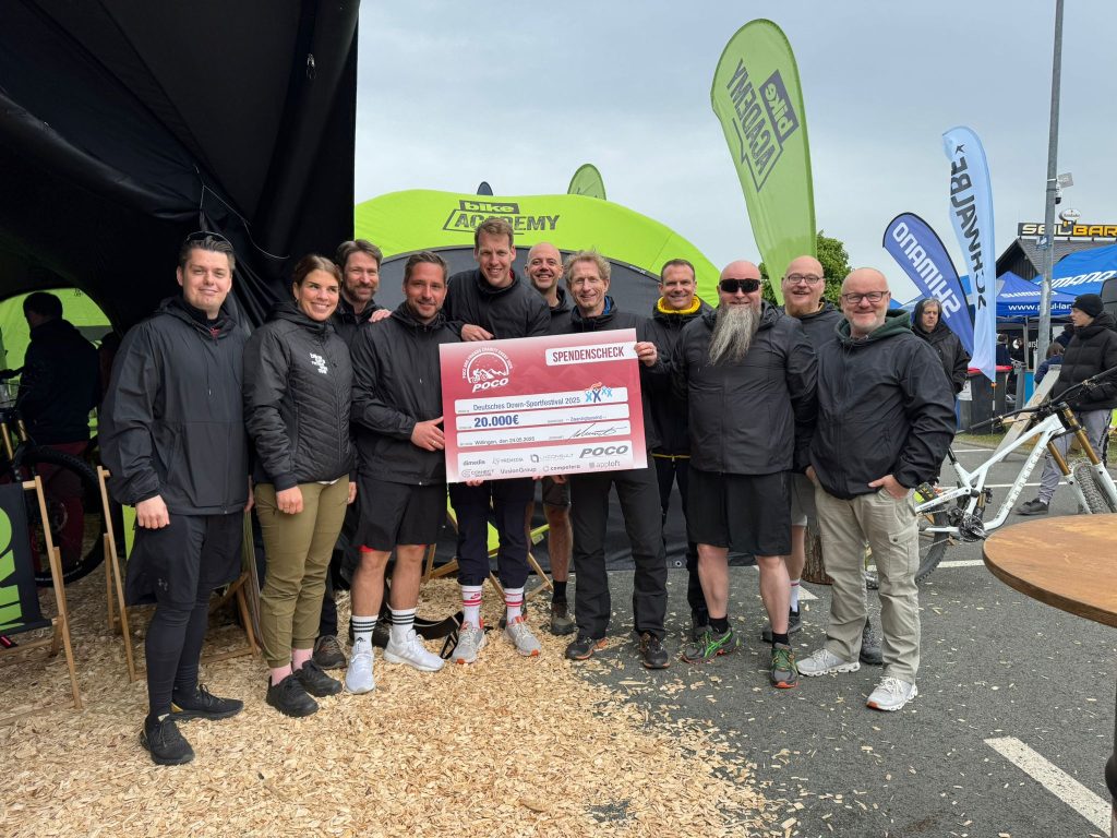 Teams von POCO und Partnerunternehmen mit dem Scheck beim Bike Festival in Willingen 2025