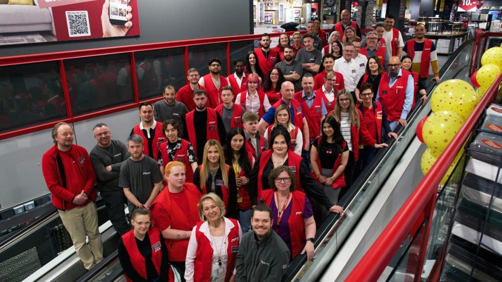 Gruppenbild auf Rolltreppe von oben mit dem Team des neuen POCO-Markts Karlsruhe
